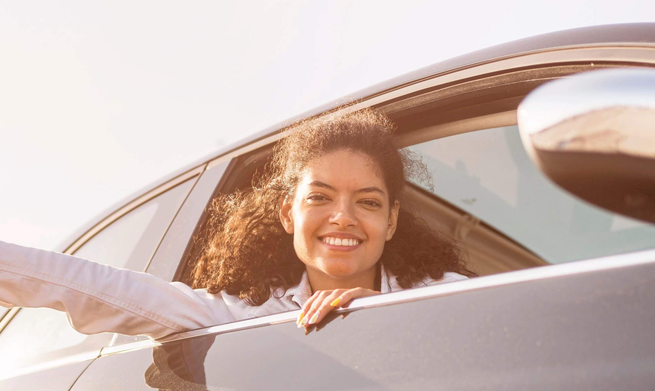 Driver smiling while leaning out of a car window